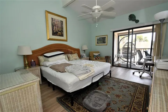 a bedroom with a bed a table and large windows