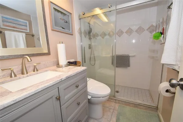 a bathroom with a granite countertop sink toilet and shower