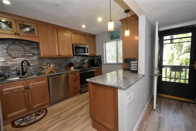 a kitchen with a sink a counter top space appliances and cabinets