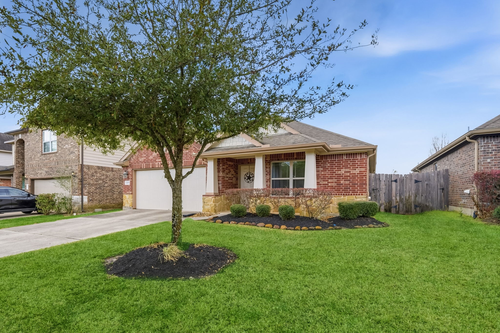 24118 McKinzie Ridge Drive Porter, TX 77365 - Photo 1 of 25 a front view of a house with a garden and trees