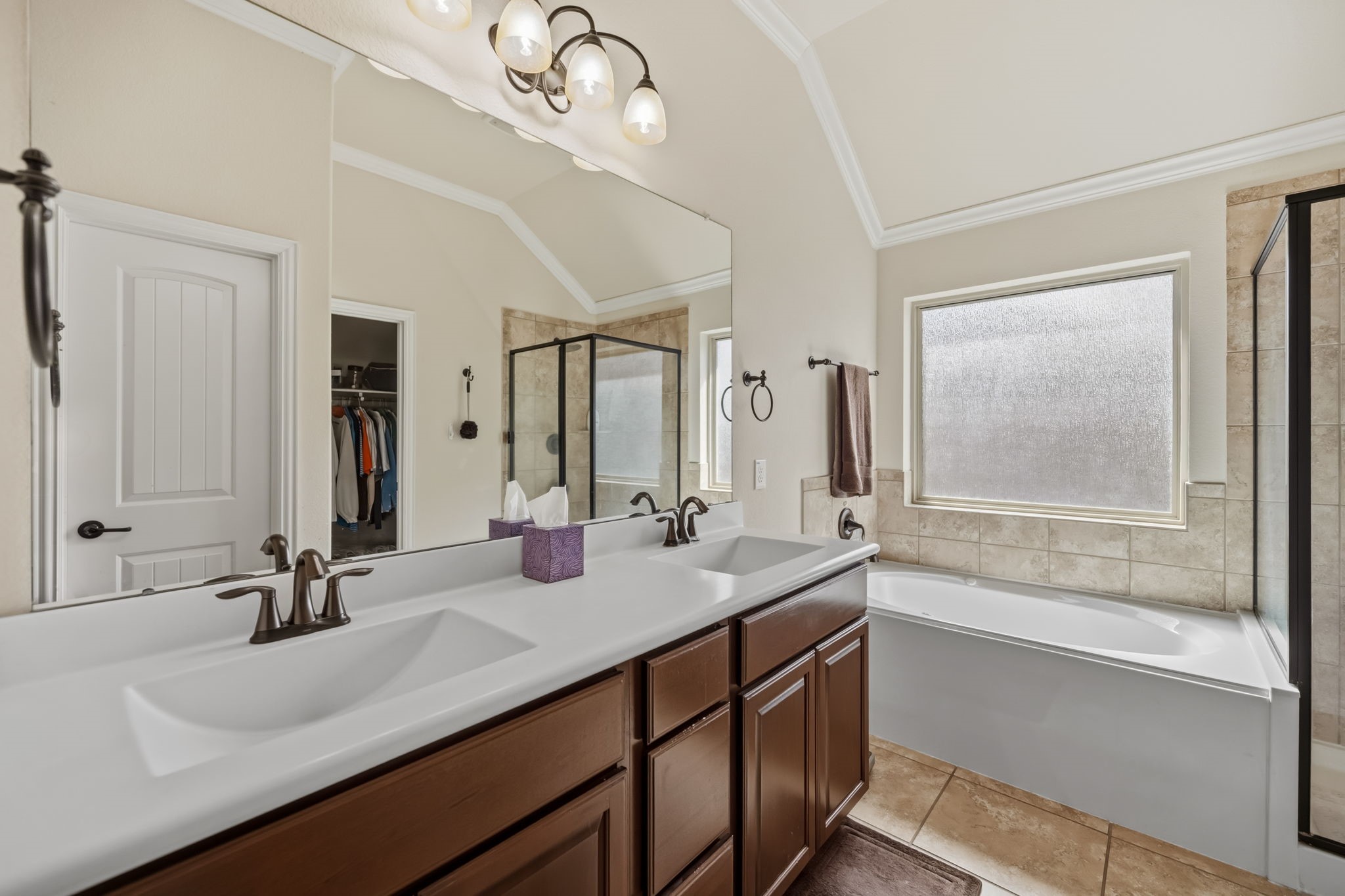 24118 McKinzie Ridge Drive Porter, TX 77365 - Photo 20 of 25 a bathroom with double vanity sinks a large mirror and a bathtub