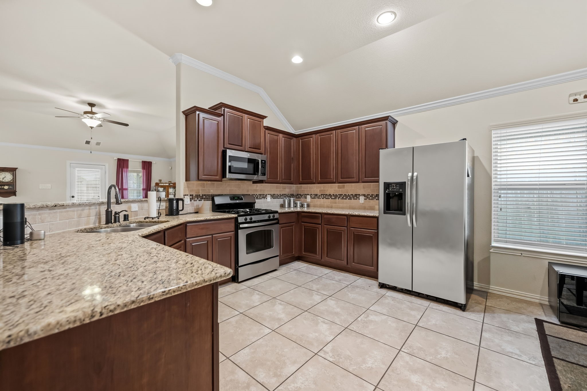 24118 McKinzie Ridge Drive Porter, TX 77365 - Photo 8 of 25 a kitchen with granite countertop a refrigerator and a stove top oven