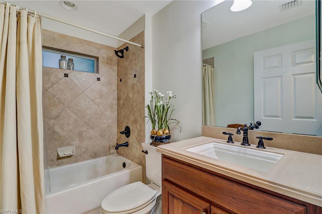19731 Villa Rosa Loop Estero, FL 33967 - Photo 15 of 27 a bathroom with a sink a toilet a mirror a bathtub and shower