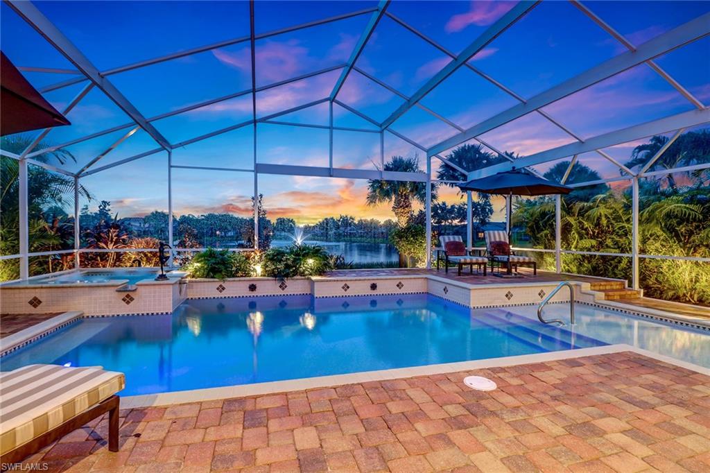 19731 Villa Rosa Loop Estero, FL 33967 - Photo 24 of 27 a view of a swimming pool with a table and chairs under an umbrella