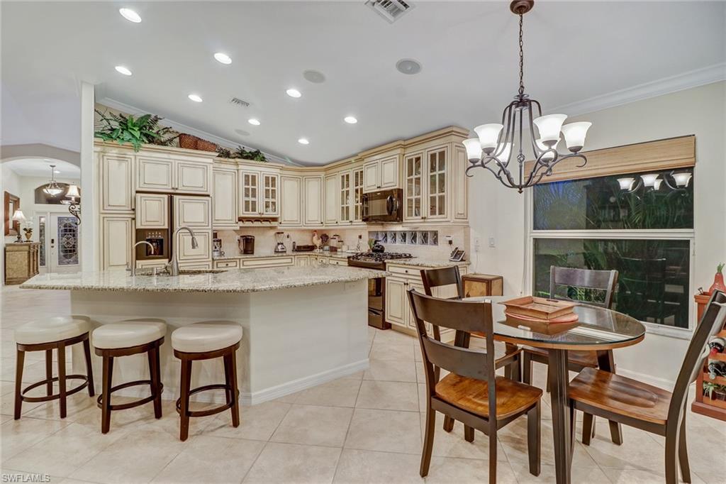 19731 Villa Rosa Loop Estero, FL 33967 - Photo 4 of 27 a dining room filled chandelier and kitchen view