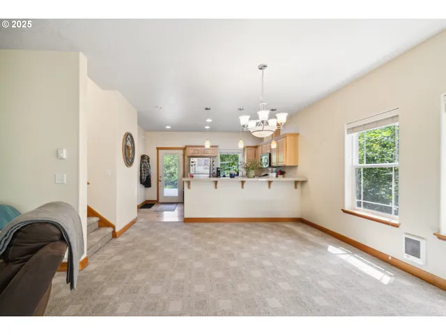 a open kitchen with a refrigerator a sink dishwasher a stove and a dining table with wooden floor