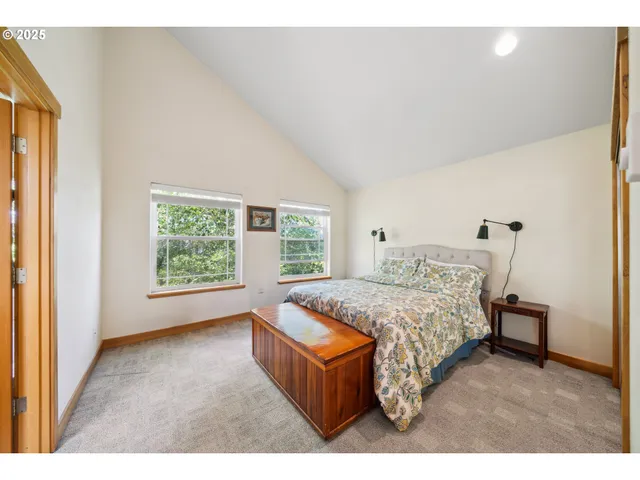 a bed sitting in a spacious bedroom next to a window