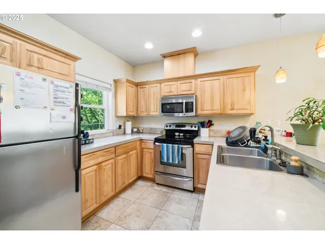 a kitchen with kitchen island a stove a sink and a refrigerator