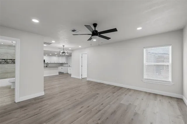 a view of empty room with wooden floor and a ceiling fan