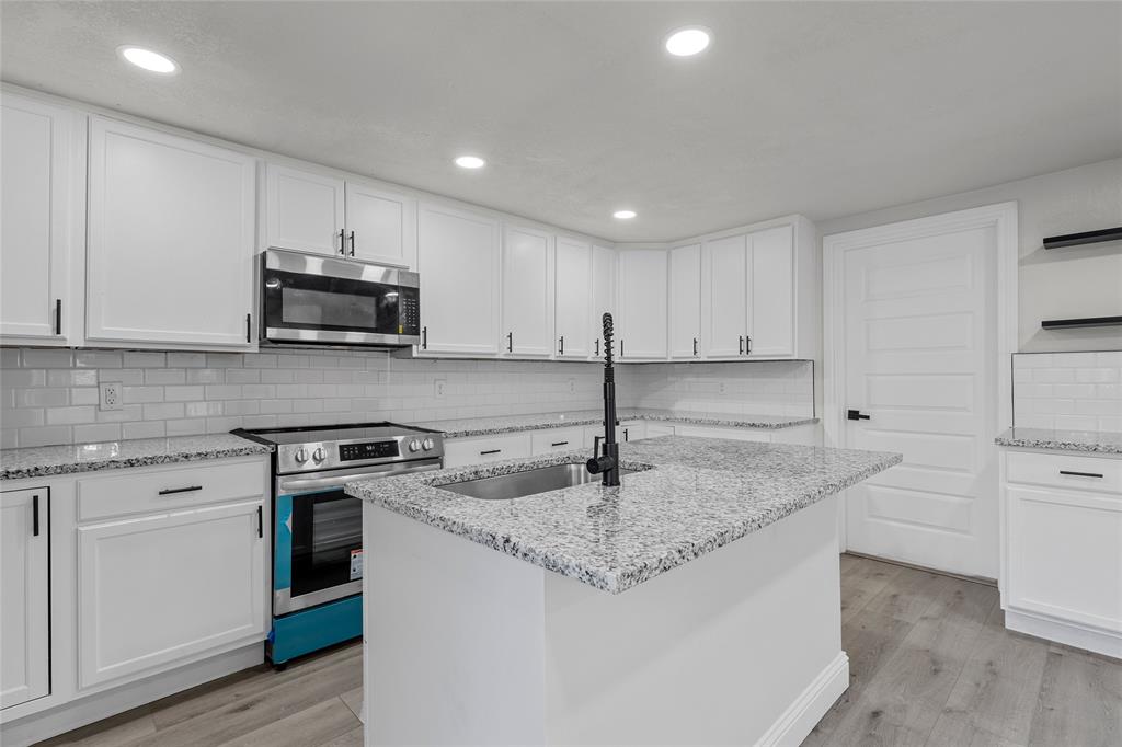 3530 Bluebird Street Bellmead, TX 76705 - Photo 8 of 24 a kitchen with stainless steel appliances granite countertop a sink stove and cabinets