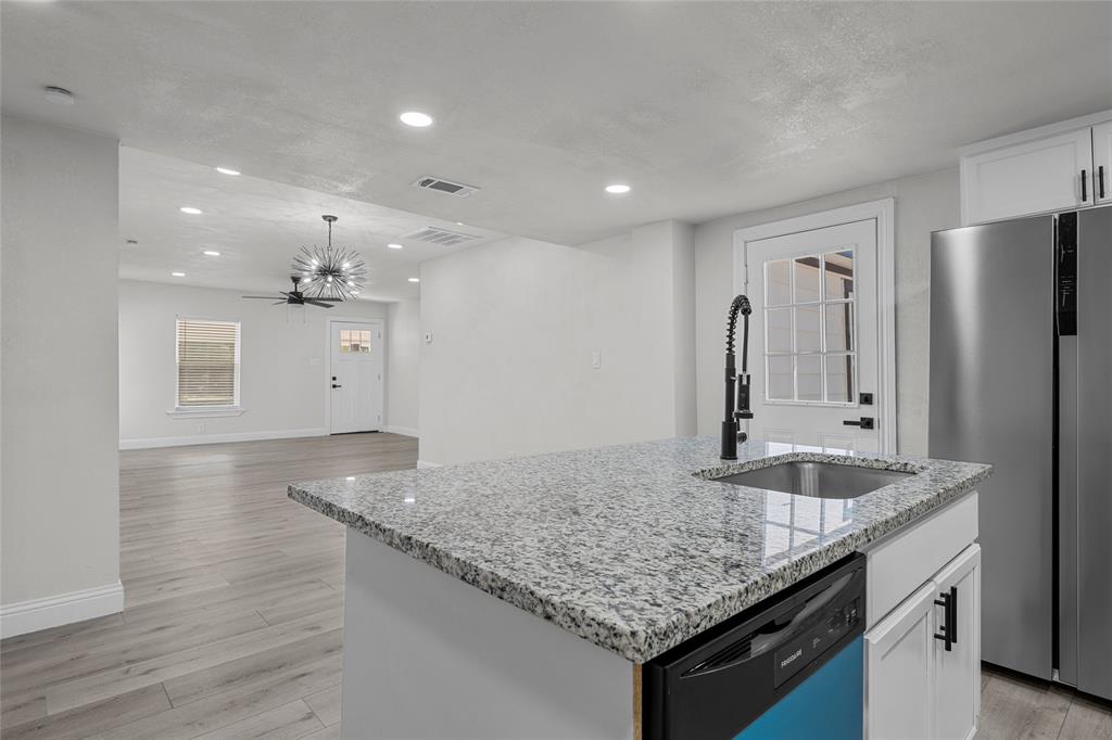 3530 Bluebird Street Bellmead, TX 76705 - Photo 9 of 24 a kitchen with stainless steel appliances granite countertop a sink refrigerator and cabinets