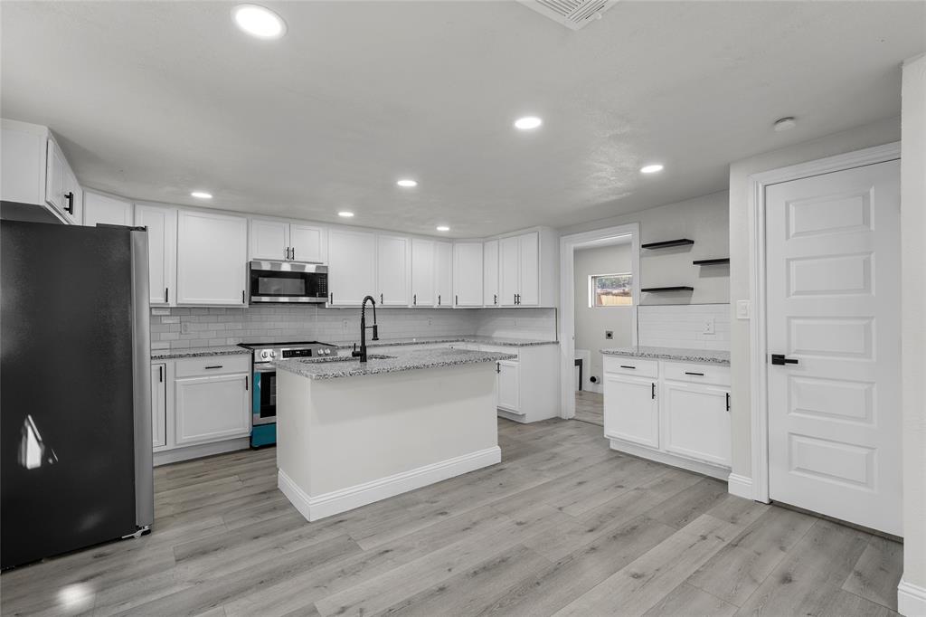 3530 Bluebird Street Bellmead, TX 76705 - Photo 10 of 24 a kitchen with stainless steel appliances a refrigerator stove microwave and cabinets