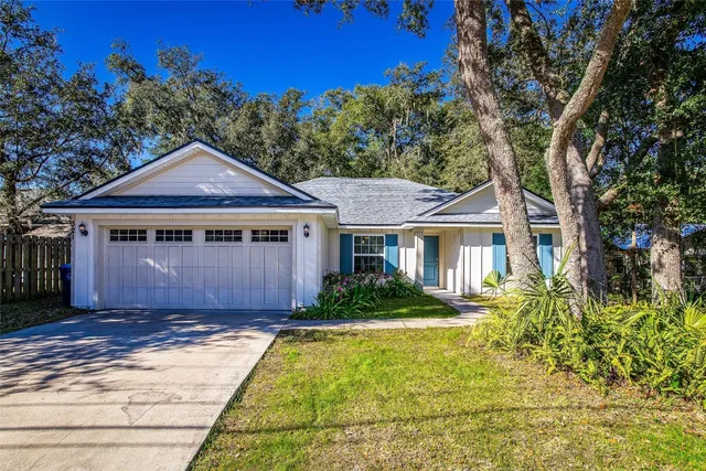 a front view of a house with a yard and trees