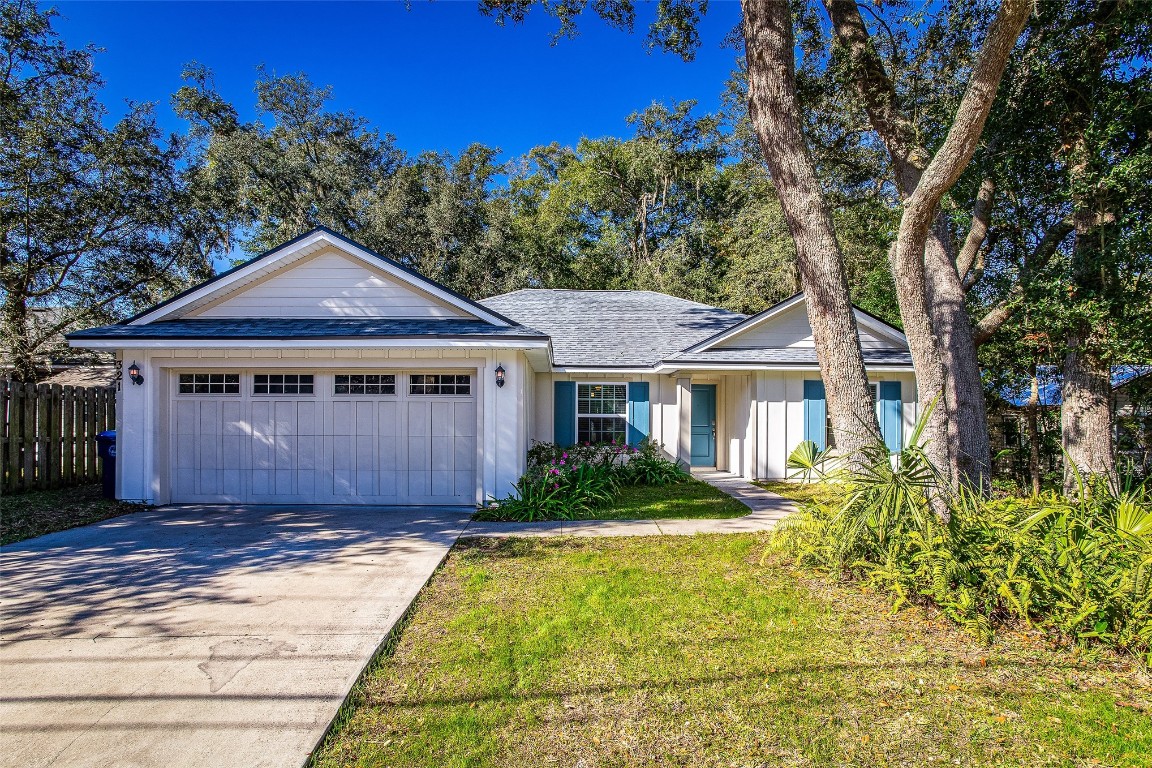 a front view of a house with a yard and trees
