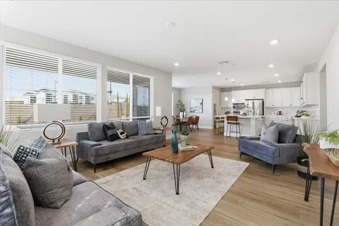 a living room with furniture and view of kitchen