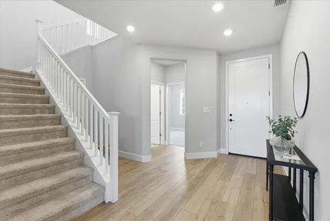 a view of a hallway with wooden floor and stairs