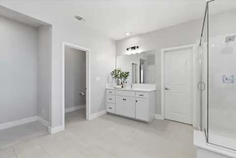 a spacious bathroom with a double vanity sink and a mirror