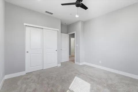 an empty room with a ceiling fan and window
