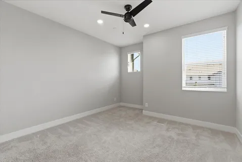 an empty room with a window and a fan