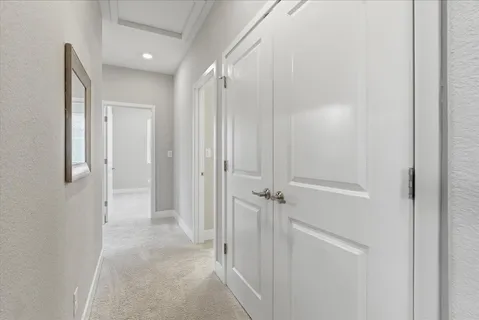 a view of a hallway with closet and a bathroom