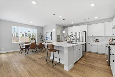a kitchen with counter space dining table and wooden floor