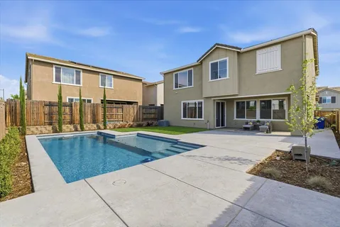 a view of a house with swimming pool and sitting area