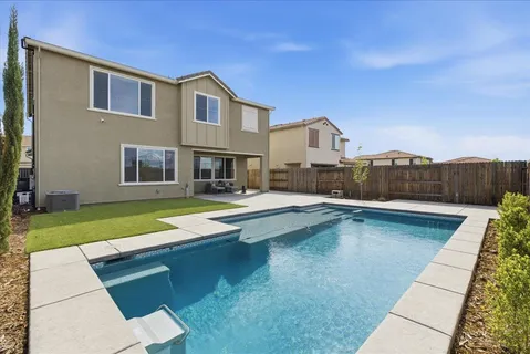a swimming pool with outdoor seating and yard