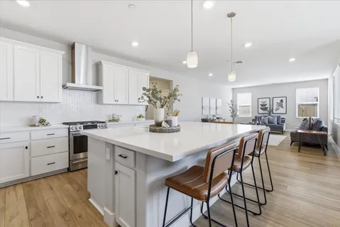 a kitchen with a dining table chairs stainless steel appliances and cabinets