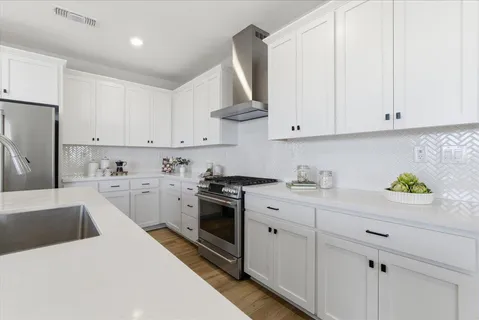 a kitchen with stainless steel appliances white cabinets and a sink