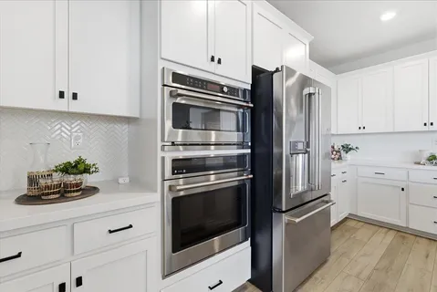 a kitchen with cabinets stainless steel appliances and wooden floor