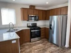 a kitchen with stainless steel appliances granite countertop a refrigerator a stove a sink and a microwave