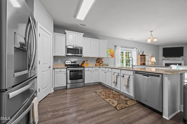 a kitchen with stainless steel appliances a stove a sink refrigerator and a microwave