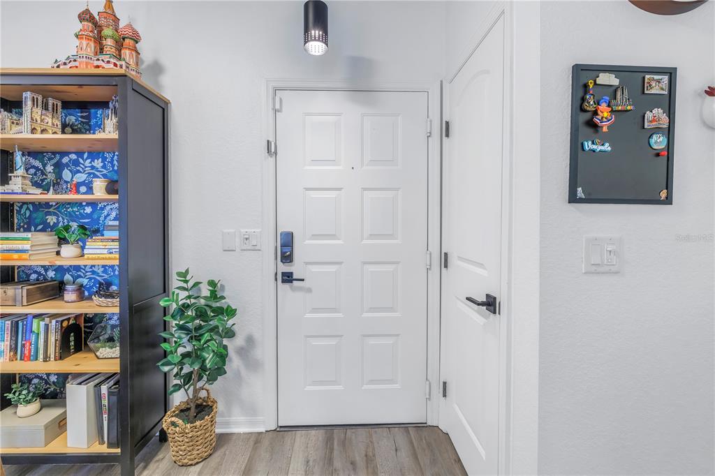4221 West Spruce Street, Unit 1325 Tampa, FL 33607 - Photo 20 of 35 a view of a hallway with bookshelf and wooden floor