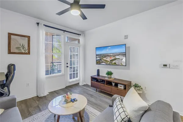 a living room with furniture a flat screen tv and a window