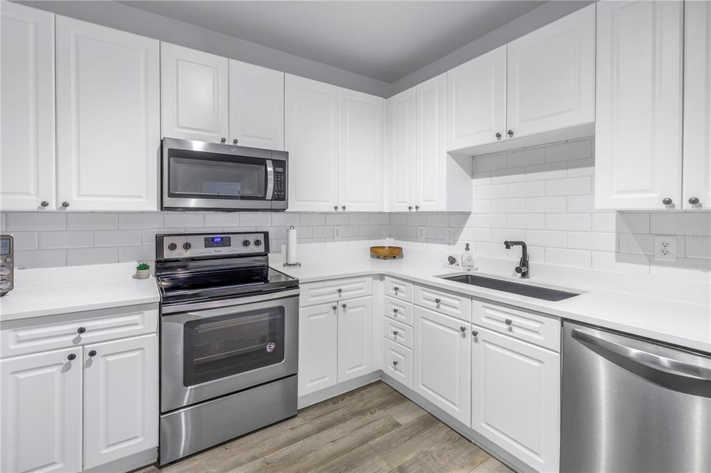 4221 West Spruce Street, Unit 1325 Tampa, FL 33607 - Photo 8 of 35 a kitchen with cabinets stainless steel appliances a sink and a counter space