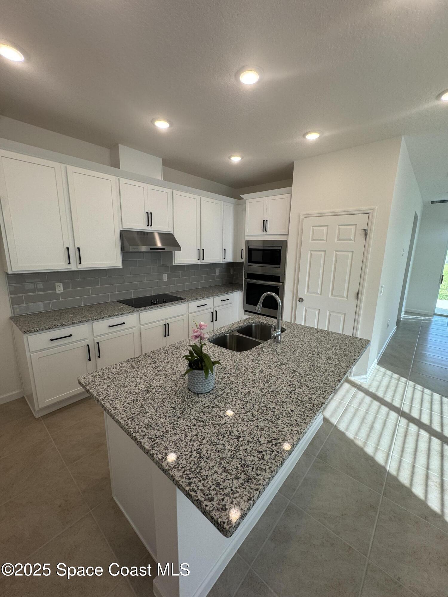 1041 Canfield Circle Palm Bay, FL 32909 - Photo 14 of 57 a kitchen with stainless steel appliances granite countertop a sink stove and refrigerator