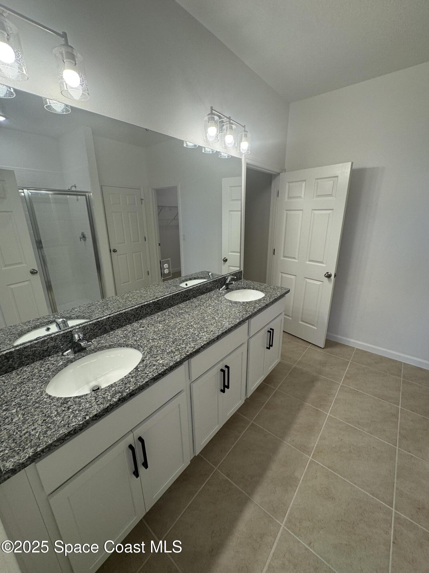 1041 Canfield Circle Palm Bay, FL 32909 - Photo 16 of 57 a bathroom with a granite countertop sink a mirror and a
