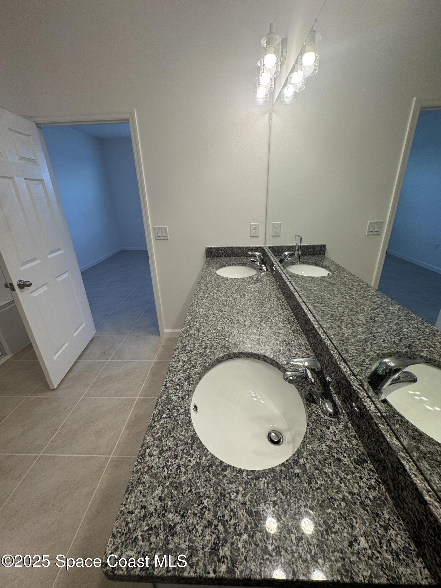 1041 Canfield Circle Palm Bay, FL 32909 - Photo 21 of 57 a bathroom with a granite countertop sink and a mirror