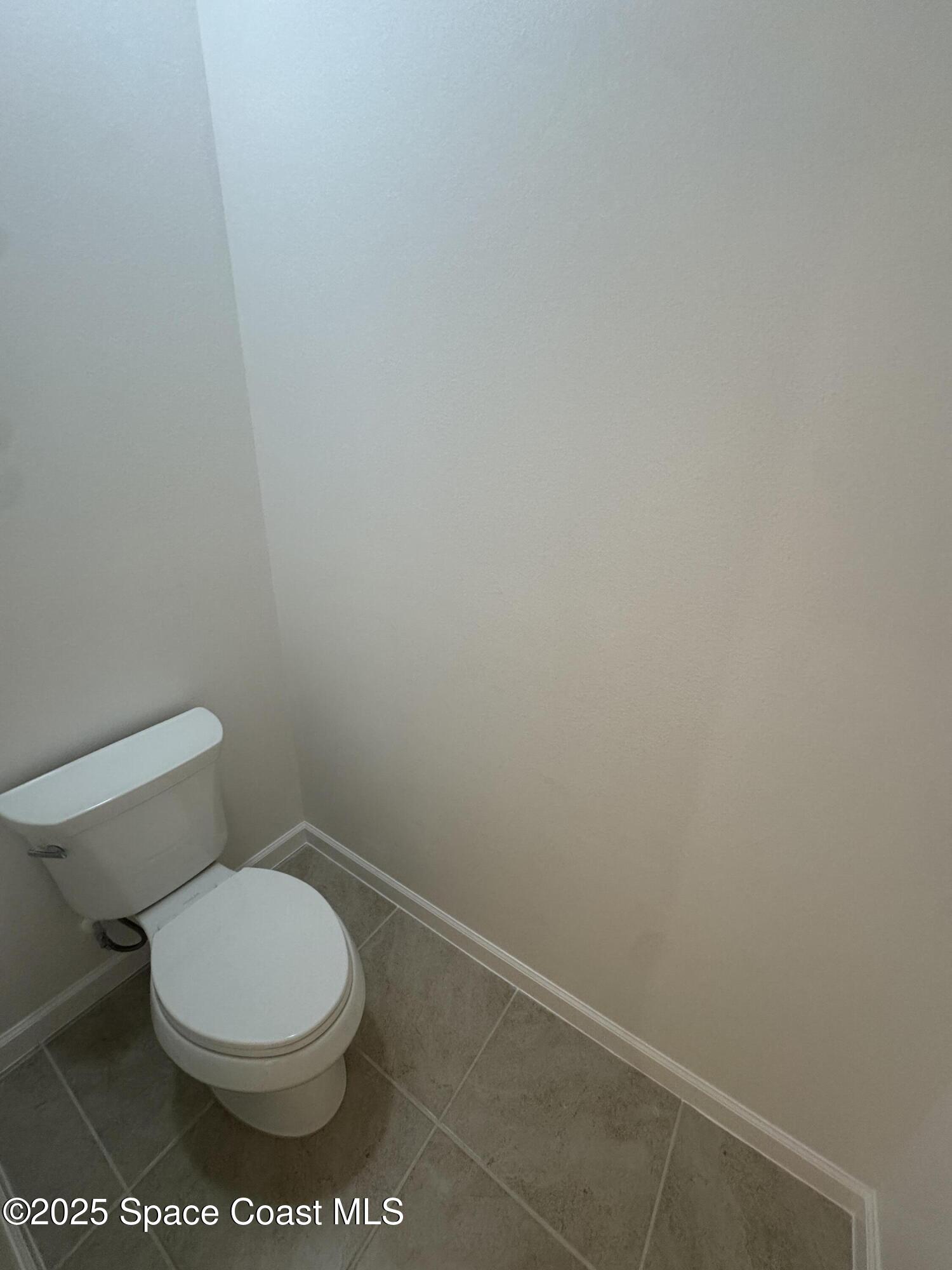 1041 Canfield Circle Palm Bay, FL 32909 - Photo 22 of 57 a white toilet sitting next to a white wall