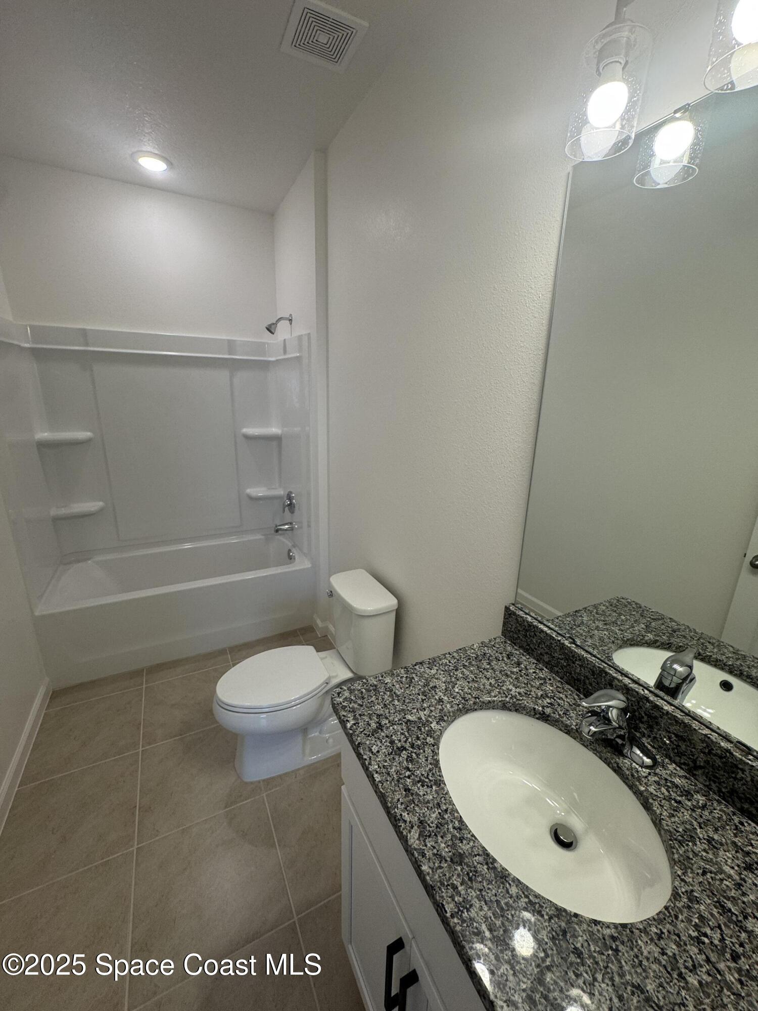 1041 Canfield Circle Palm Bay, FL 32909 - Photo 37 of 57 a bathroom with a granite countertop sink a toilet and a mirror