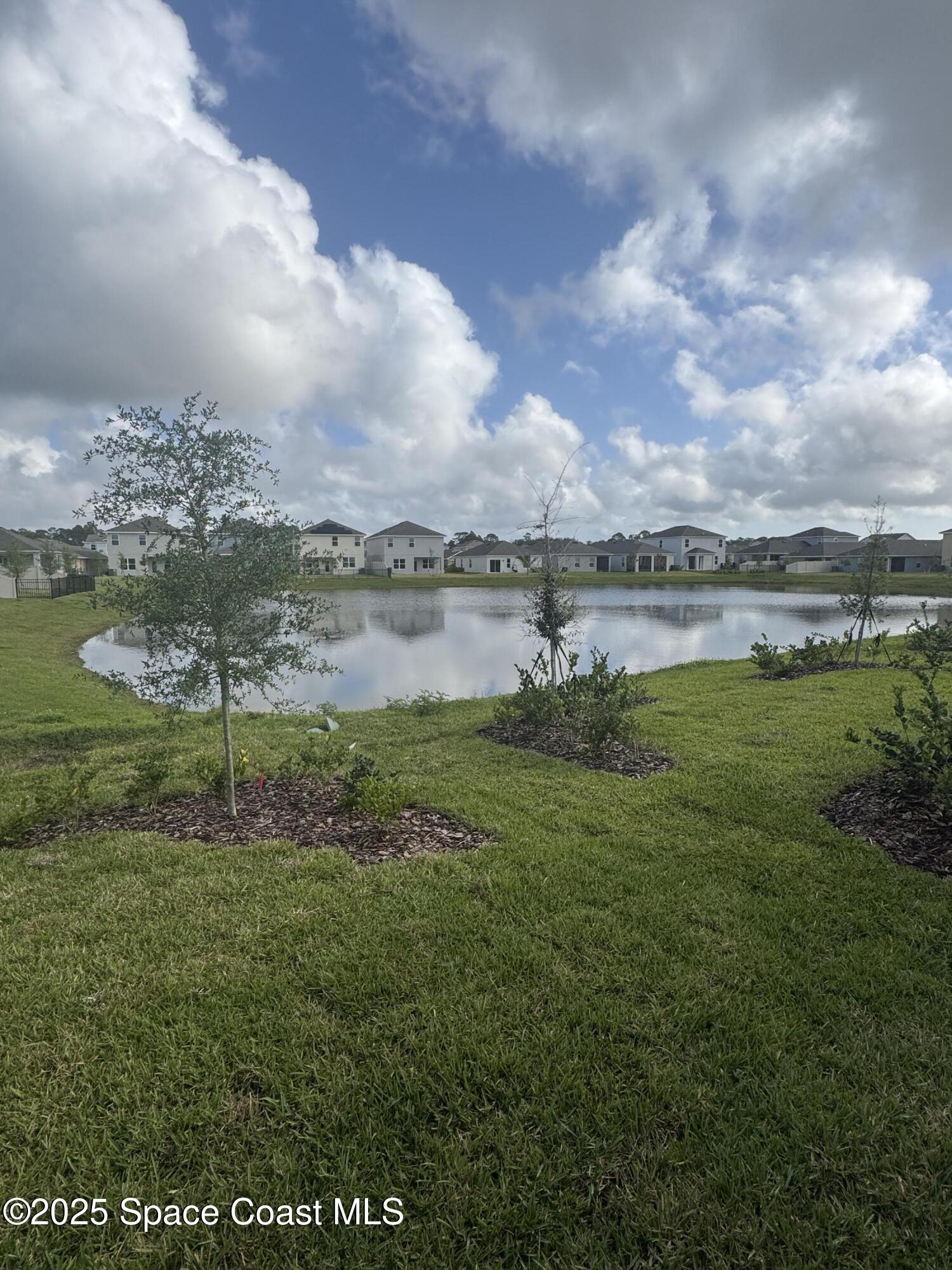 1041 Canfield Circle Palm Bay, FL 32909 - Photo 46 of 57 a view of a lake with houses in back