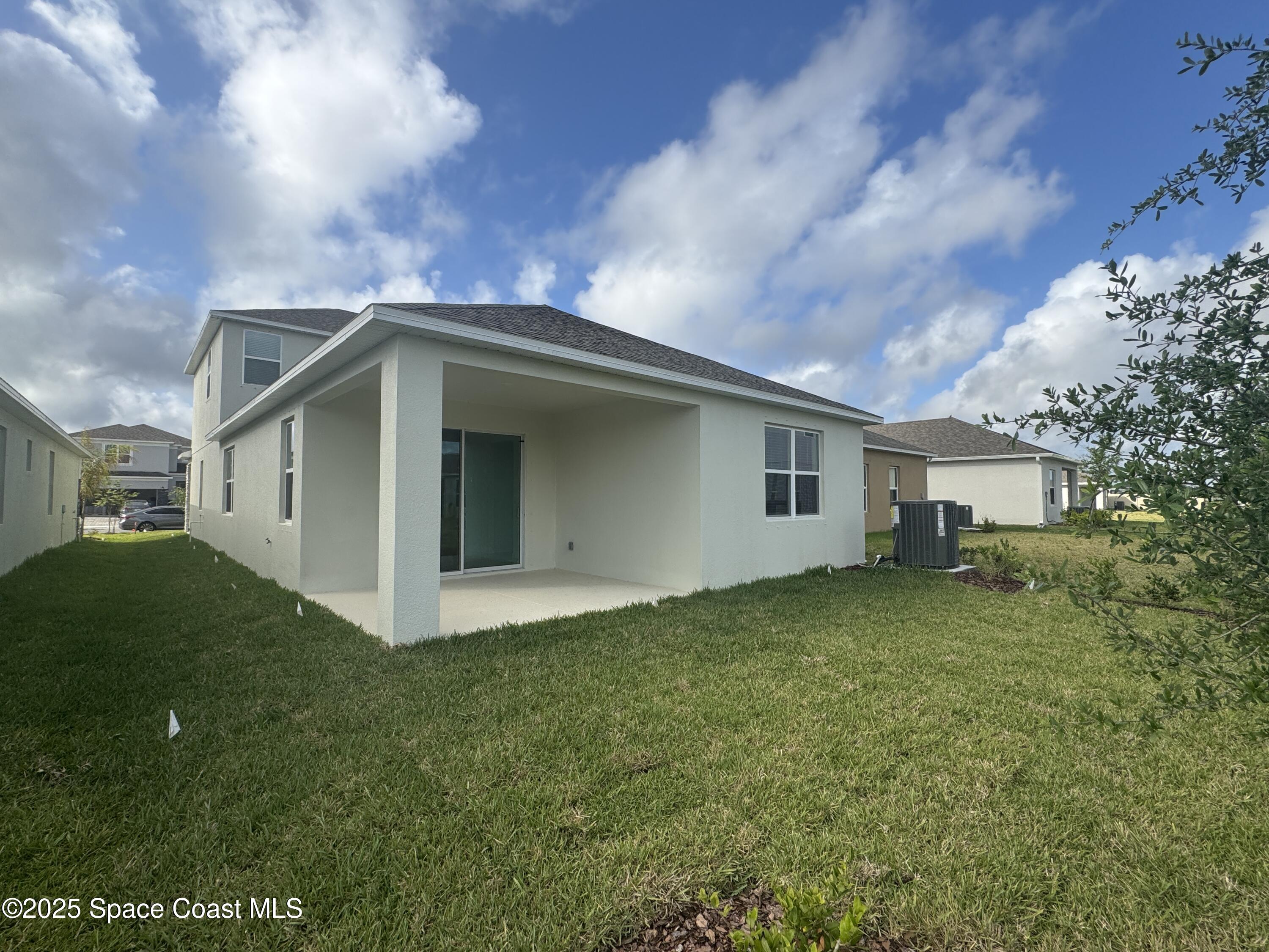 1041 Canfield Circle Palm Bay, FL 32909 - Photo 50 of 57 a front view of a house with garden
