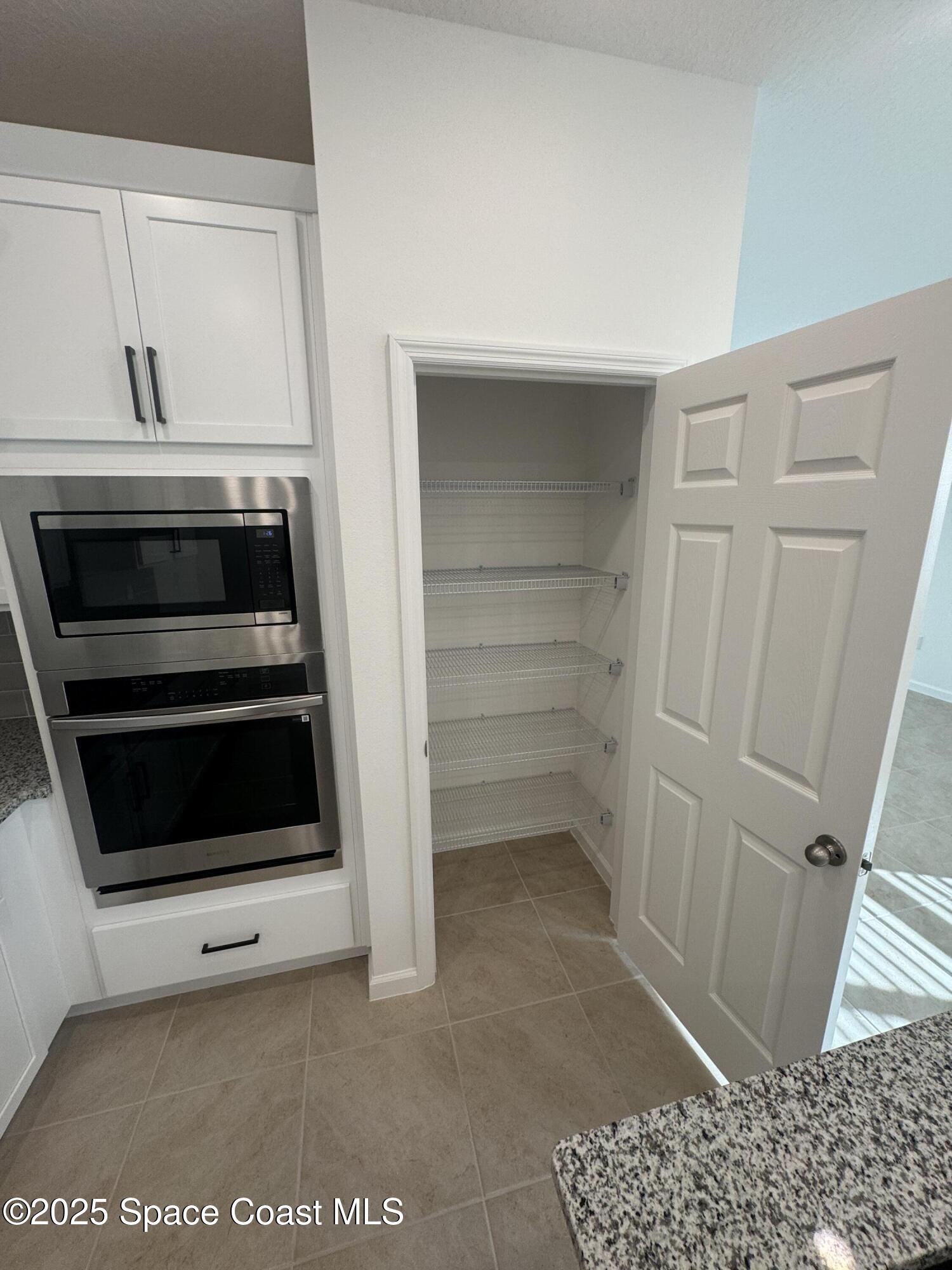 1041 Canfield Circle Palm Bay, FL 32909 - Photo 10 of 57 a utility room with washing machine and a view of cabinet
