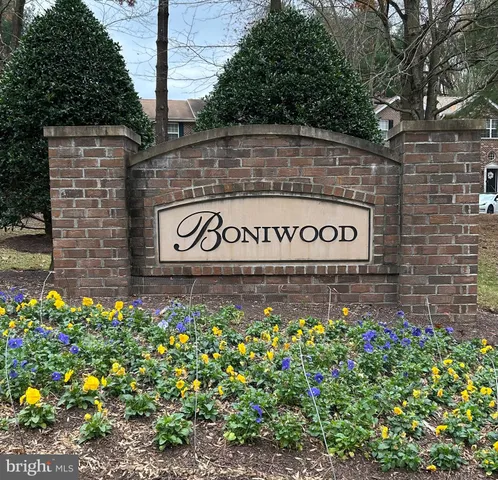 a sign that is sitting in front of flowers