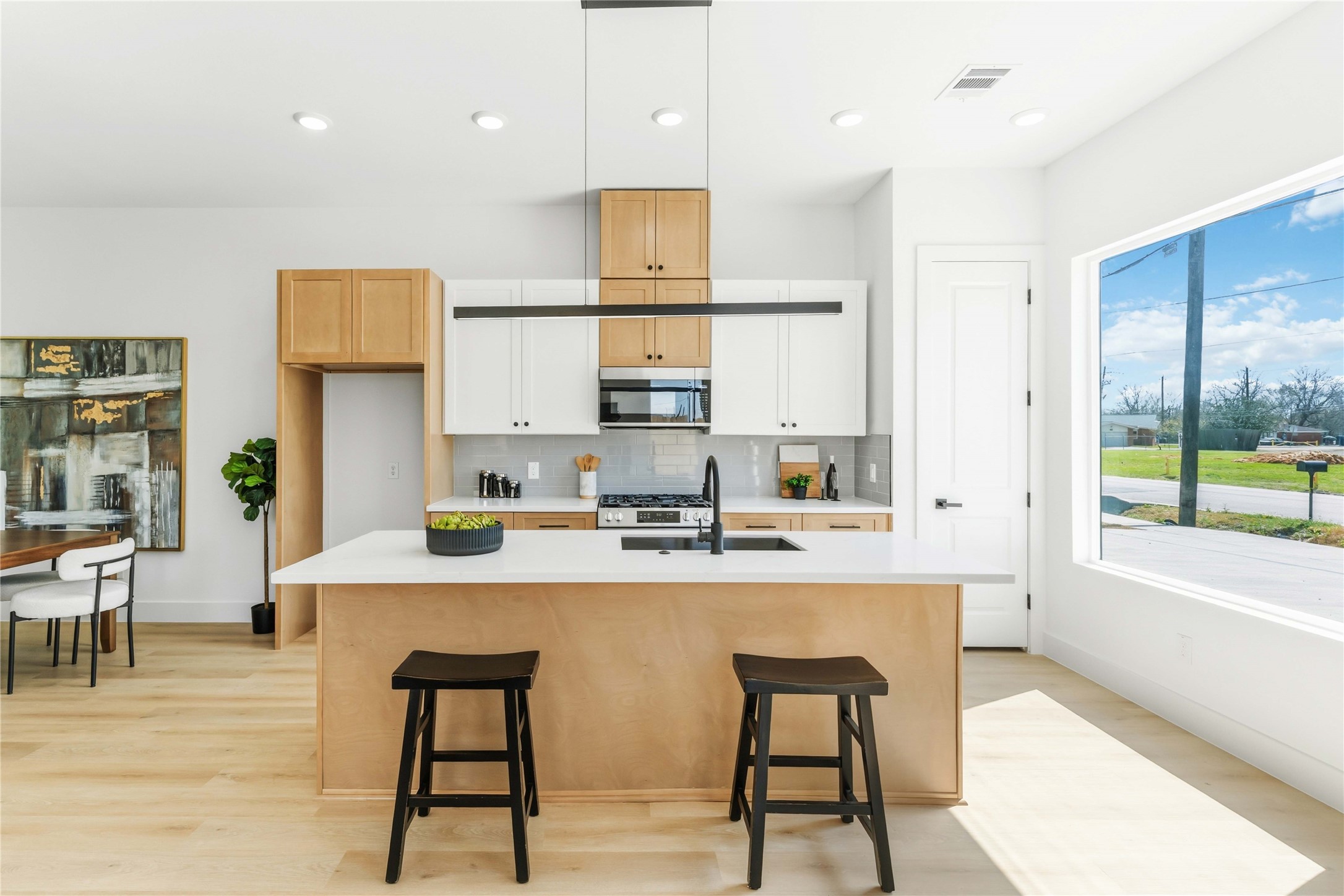 5423 Manton Street, Unit AB Houston, TX 77028 - Photo 8 of 25 a kitchen with stainless steel appliances granite countertop a table chairs refrigerator and microwave