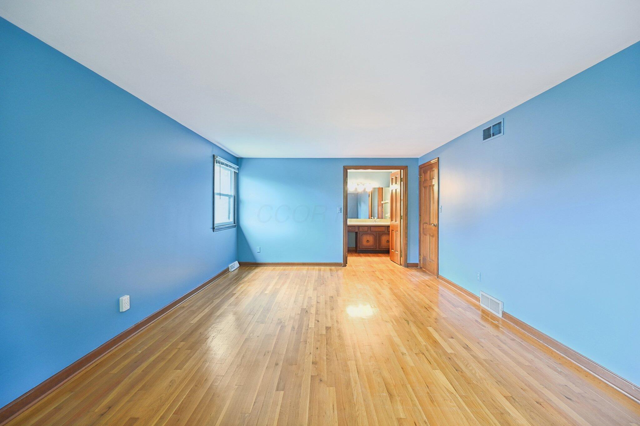 5917 Rocky Rill Road Columbus, OH 43235 - Photo 23 of 47 Alternate view of the primary bedroom highlighting direct access to the en-suite bathroom and natural hardwood flooring.