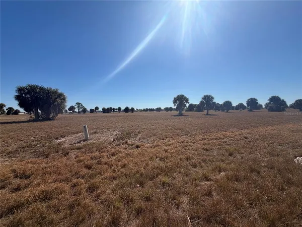 a view of a field with a building in the background