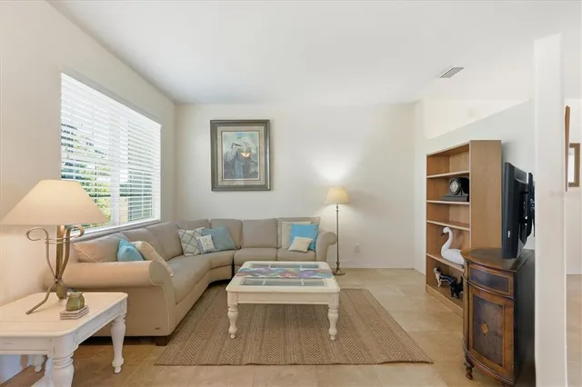 a living room with furniture a ceiling fan and a rug