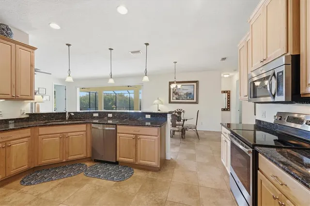 a kitchen with stainless steel appliances granite countertop a sink a refrigerator and a granite counter tops