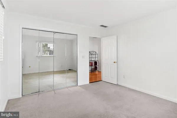 an empty room with closet and mirrors